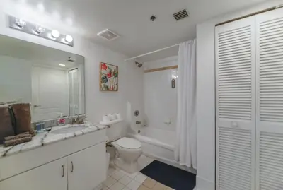 a white bathroom with a toilet and a sink at Luxury Suite | Sauna, Pool & Resort Access in Miami
