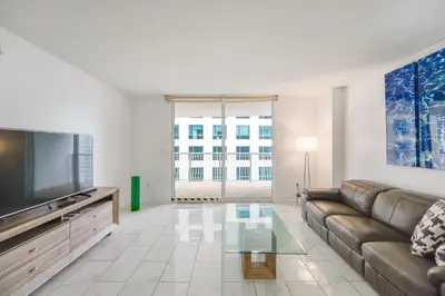 a living room with a couch and a flat screen tv at Luxury Bayview Condo | Pool, Gym & Skyline Views in Miami