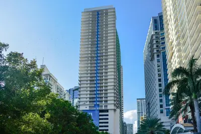 a tall building with blue stairs on it in a city at Luxury Bayview Condo | Pool, Gym & Skyline Views in Miami