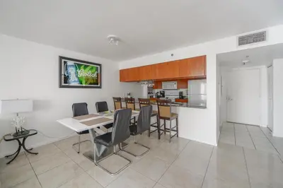 a dining room and kitchen with a table and chairs at Luxe 2BD Unit | W Sauna, Pool & Gym access in Miami