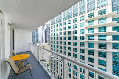 a balcony with a table and a chair and a building at Luxe 2BD Unit | W Sauna, Pool & Gym access in Miami