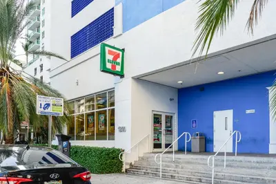 a blue and white building with a car parked outside at Luxe 2BD Unit | W Sauna, Pool & Gym access in Miami