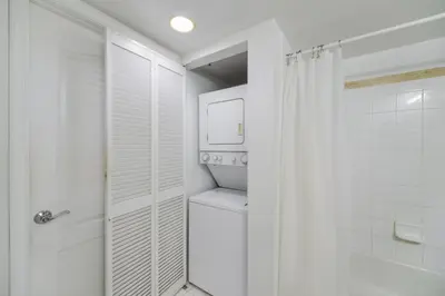 a white bathroom with a toilet and a shower at Luxury 2BD Condo | Sauna, Pool & Resort Access in Miami