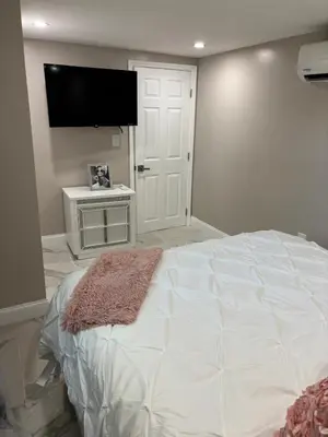 a bedroom with a large bed and a flat screen tv at Peace and Tranquility awaits in Miami Gardens