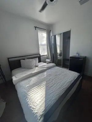 a bedroom with a large white bed with a window at Cozy Home away from home! in Miami
