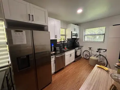 a kitchen with a refrigerator and a bike in it at Cozy Home away from home! in Miami