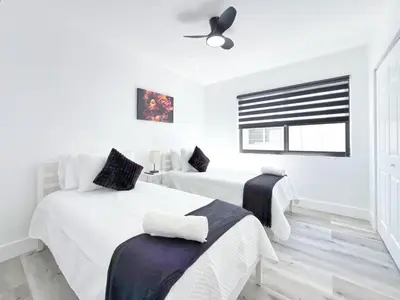 a white bedroom with two beds and a window at Miami Lux Retreat - Free Parking - Near Brickell in Miami