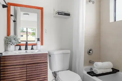 a bathroom with a toilet and a sink and a mirror at Unit 1 Cozy 1BR Apt with Parking in Miami