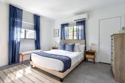 a bedroom with a large bed with blue curtains at Unit 4 Beautiful 1BR Apt w Parking Near Biscayne Blvd in Miami