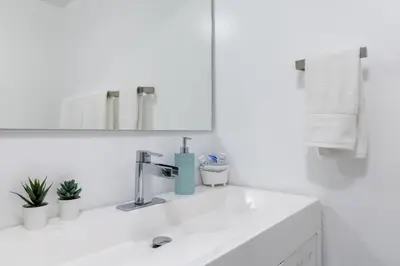 a white bathroom with a sink and a mirror at Hollywood 1 BR Apt w Gym and Pool near the Beach in Hollywood