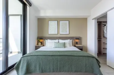 a bedroom with a large bed with a green blanket at 72 Park Ocean view 1BR Apartment with Pool and Gym in Miami Beach
