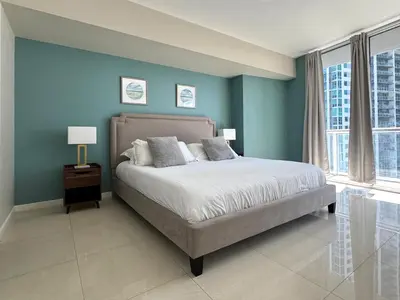 a bedroom with a bed with blue walls and windows at Elegant 1B at Icon Brickell 17th fl Pool, Spa Gym FREE Parking Scenic view in Miami