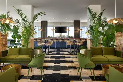 a hotel lobby with green chairs and a bar at Elegant 1B at Icon Brickell 17th fl Pool, Spa Gym FREE Parking Scenic view in Miami