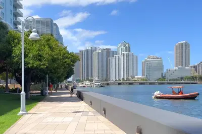 a boat in a river with a city in the background at Elegant 1B at Icon Brickell 17th fl Pool, Spa Gym FREE Parking Scenic view in Miami