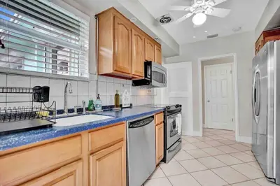 a kitchen with wooden cabinets and stainless steel appliances at Cozy three bedroom near Hollywood beach in Hollywood