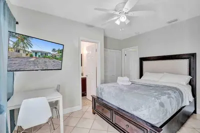 a bedroom with a bed and a desk and a tv at Cozy three bedroom near Hollywood beach in Hollywood