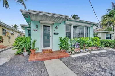 a green house with a front door and plants at Cozy three bedroom near Hollywood beach in Hollywood