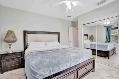 a bedroom with a large bed and a mirror at Cozy three bedroom near Hollywood beach in Hollywood