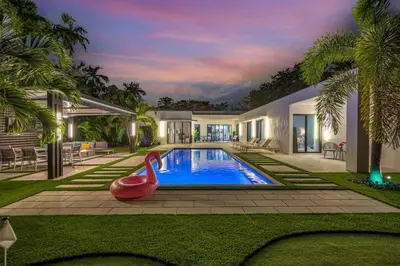 a house with a swimming pool with a pink swan in the yard at Private Villa with Heated Pool, Basketball Court and BBQ in Miami