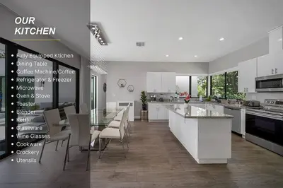 a kitchen with white cabinets and a table and chairs at Private Villa with Heated Pool, Basketball Court and BBQ in Miami