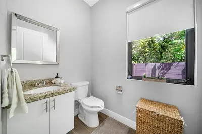 a white bathroom with a toilet and a window at Private Villa with Heated Pool, Basketball Court and BBQ in Miami