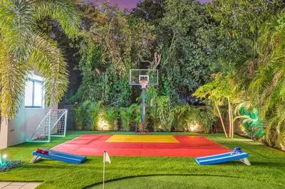 a basketball court with a basketball hoop on the grass at Private Villa with Heated Pool, Basketball Court and BBQ in Miami