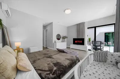 a bedroom with a large bed and a living room at Private Villa with Heated Pool, Basketball Court and BBQ in Miami