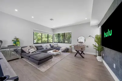 a living room with a couch and a flat screen tv at Private Villa with Heated Pool, Basketball Court and BBQ in Miami
