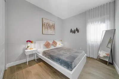 a white bedroom with a bed and a mirror at Private Villa with Heated Pool, Basketball Court and BBQ in Miami