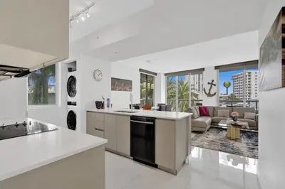 a large white kitchen with a living room with a couch at Ocean View 3 BDR Condo Pool Gym Private Balcony in Hallandale Beach