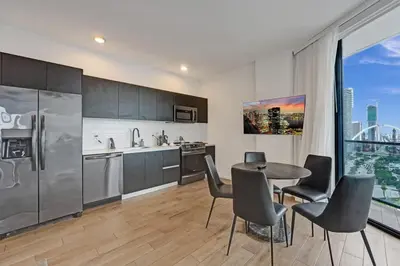 a kitchen with a table and chairs and a refrigerator at Miami 30th floor 3BR Luxury Condo with Views in Miami
