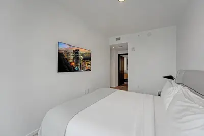 a bedroom with a white bed with a picture on the wall at Miami 30th floor 3BR Luxury Condo with Views in Miami