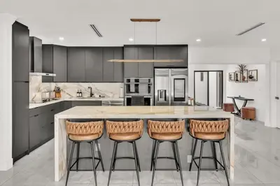 a kitchen with a large island with four bar stools at Lux Villa Heated Pool, Gym, Games, Golf, Near Beach in Hollywood