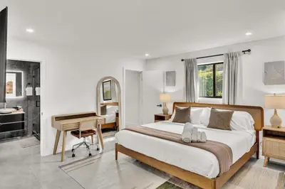 a bedroom with a large bed and a desk and a desk at Lux Villa Heated Pool, Gym, Games, Golf, Near Beach in Hollywood