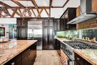 a kitchen with wooden cabinets and a stove at The Porch House - 3 Bed 2 Bath Pool Home in Hollywood