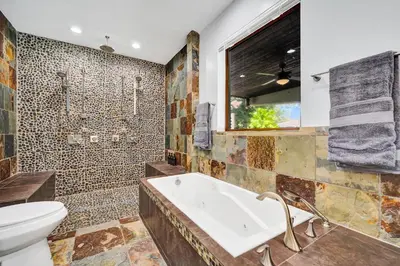 a bathroom with a tub and a toilet at The Porch House - 3 Bed 2 Bath Pool Home in Hollywood