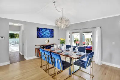 a dining room with a table and blue chairs at Oasis 5 Bed, 3 Bath Pool Home Minutes to the Beach in Hollywood