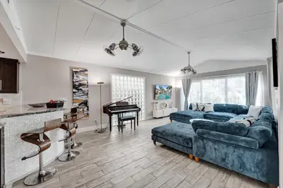 a living room with a blue couch and a piano at Oasis 5 Bed, 3 Bath Pool Home Minutes to the Beach in Hollywood