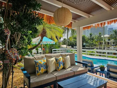 a couch sitting on a patio with a pool at The Bird-2 blocks to beach-Heated Pool-Hot Tub in Fort Lauderdale