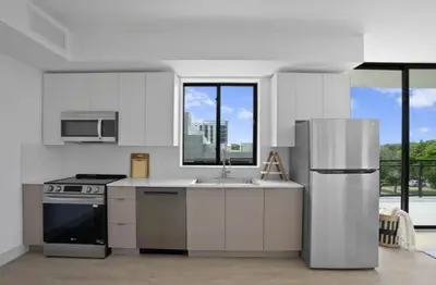 a kitchen with a stainless steel refrigerator and a sink at 3B-2B in Resort style community- Prime Miami Spot in North Miami
