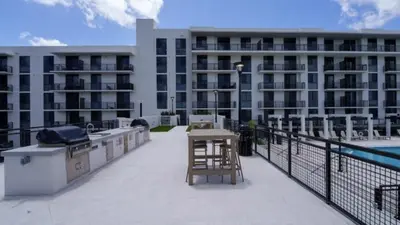 a balcony with a table and a grill on a building at Sleep 6 in Resort Style Community- Near Stadium in North Miami