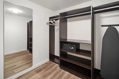 a walk in closet with black shelves and a mirror at The Grayson Hotel Miami Downtown in Miami