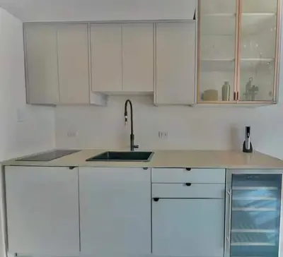 a white kitchen with a sink and white cabinets at Chic & Cozy 1BR in Miami Best South Beach Location in Miami Beach