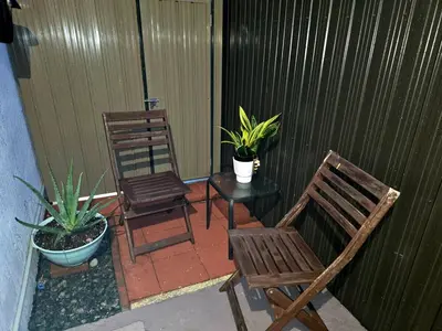 two chairs and a table on a patio with plants at Miami Mini Escape 5 minutes from the airport in Miami