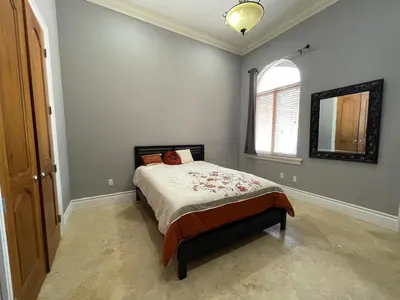 a bedroom with a bed and a mirror on the wall at Miami Mansion for Groups Sleeps 12 in Kendale Lakes