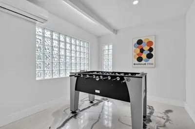 a black stove in a white room with windows at Waterfront Pool Home Games, 10 min to Beach in Fort Lauderdale