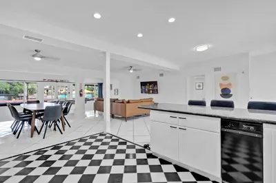 a kitchen with a black and white checkered floor at Waterfront Pool Home Games, 10 min to Beach in Fort Lauderdale