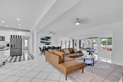 a living room with a couch and a kitchen at Waterfront Pool Home Games, 10 min to Beach in Fort Lauderdale
