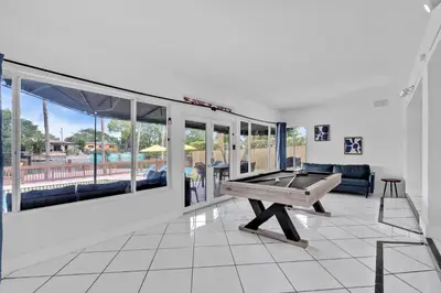 a living room with a ping pong table in it at Waterfront Pool Home Games, 10 min to Beach in Fort Lauderdale