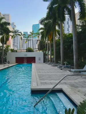 a swimming pool with palm trees in a city at Modern Luxury Studio for Two in Downtown in Miami